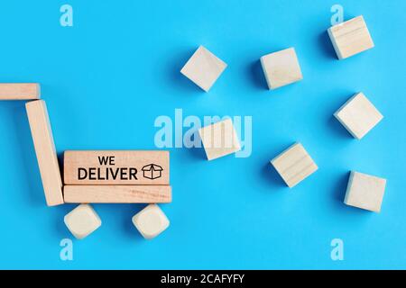 Package transportation cart and cargo parcels made of wooden blocks with the words we deliver. Cargo or parcel delivery service concept Stock Photo