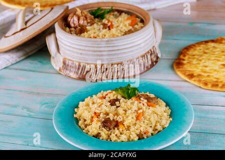 Delicious indian lunch with stewed rice ,meat and carrot in plate with flatbread. Stock Photo