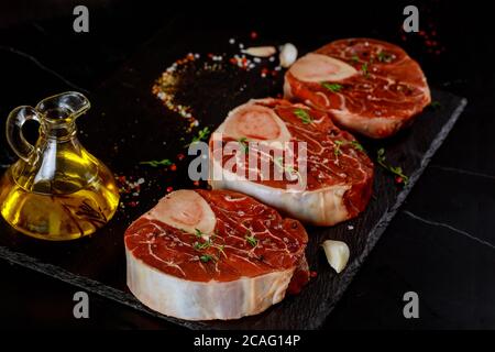 Three pieces of raw fresh beef shank bone in with spices and herb. Stock Photo