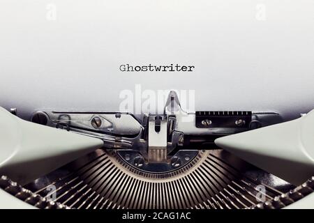 The word ghostwriter typed on the paper with a vintage typewriter. Close up flat lay view Stock Photo