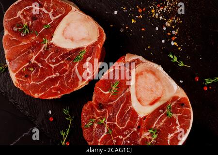 Two pieces of raw fresh beef shank bone in with spices and herb. Stock Photo
