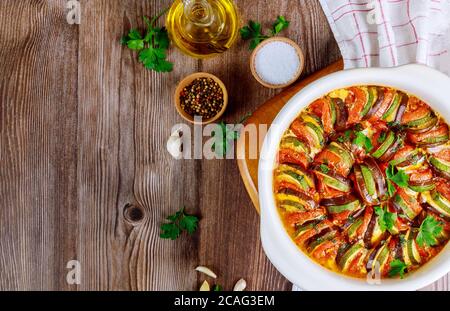 Vegetable ratatouille baked in white oven pan. French vegetarian dish. Top view. Stock Photo