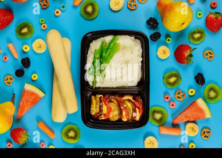 Vegetarian lunch in a container. Mashed potatoes with asparagus, vegetables and bread stick. Stock Photo
