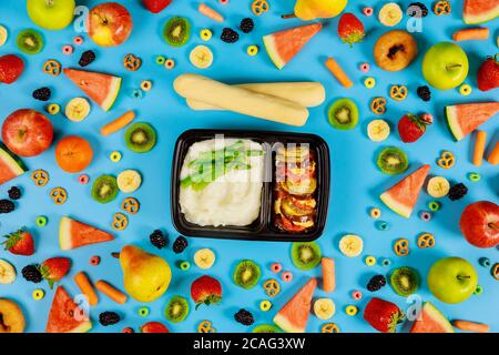 Lunch delivery in a plastic container. Mashed potatoes with asparagus, vegetables and bread stick. Stock Photo