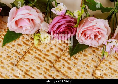 Matzah bread with pink roses. Jewish Passover holiday concept. Close up. Stock Photo