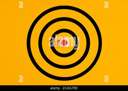 Target with  a wooden block as the bulls eye on yellow background. Concept of focusing on a target. Stock Photo