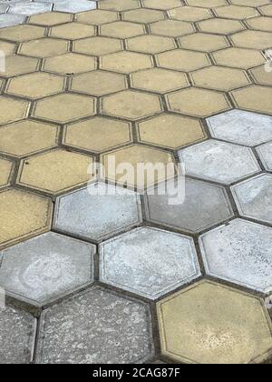Seamless texture of hexagon concrete street tiles. repeating pattern of yellow and gray honeycomb pavement stones Stock Photo