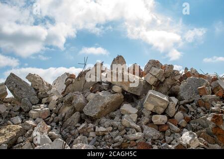 A pile of concrete fragments of a destroyed building against the blue sky Stock Photo