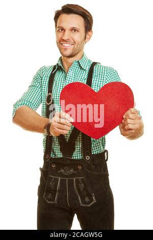 Smiling man in leather pants holds a big red heart Stock Photo