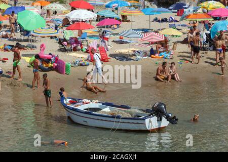 11.08.2018, Cefalu, Sicily, Italy - Tourists and locals relax on the city beach under umbrellas and swim in the Mediterranean Sea. 00U180811D006CAROEX Stock Photo