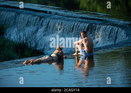 People enjoy an early morning swim at Warleigh Weir on the River Avon near Bath in Somerset as temperatures are set soar across the United Kingdom. Stock Photo