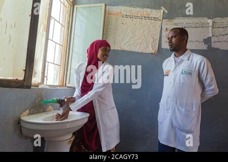 12.11.2019, Denan, Somali Region, Ethiopia - In a treatment room of the Denan Hospital, a doctor washes her hands in a washbasin under running water. Stock Photo