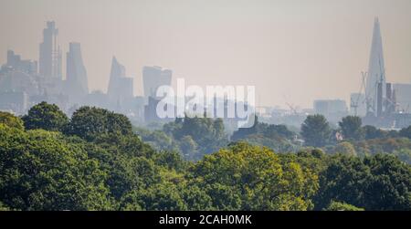 Richmond Park, London, UK. 7 August 2020. Skyscrapers of central London shimmer through a morning heat haze, seen from the green oasis of Richmond Park on a day when temperatures might break records. Credit: Malcolm Park/Alamy Live News. Stock Photo