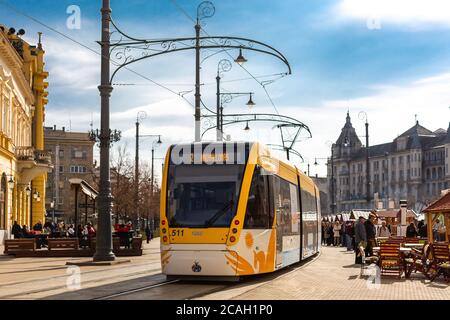 Debrecen, Hungary - March 02, 2019: Modern yellow tram at street in historical ?enter of Debrecen, Hungary Stock Photo