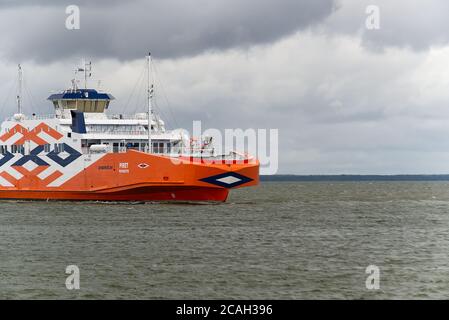 VIRTSU, ESTONIA - JULY 30, 2020: Big passanger ferry Connecting Estonia mainland and Muhu island. Orange Piret Ferry on cloudy day, goingto Saaremaa. Stock Photo