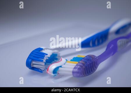 two toothbrushes on a white background next to the toothpaste. healthy and clean teeth concept, dentistry. High quality photo Stock Photo