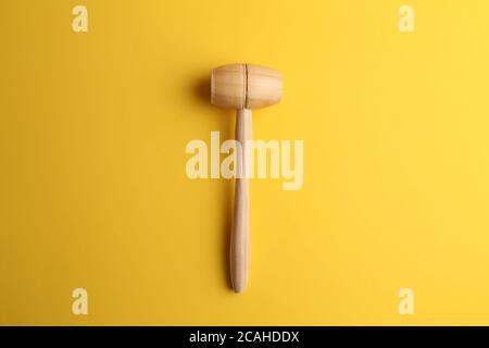 Top view of a wooden kitchen hammer isolated on a yellow background Stock Photo