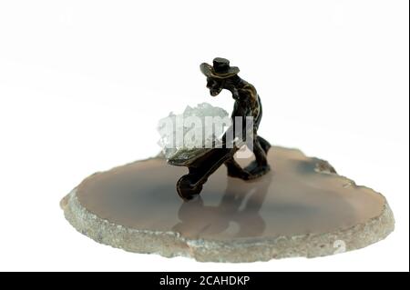 Isolated small metal miner figurine on a stone Stock Photo
