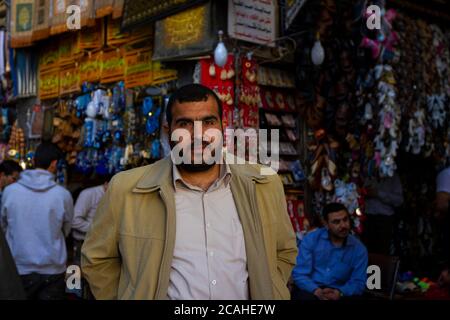 Damascus, Syria 03/28/2010: Selective focus portrait of a bearded Syrian shopkeeper in Al Hamidiyah Souq as he stands in front of  displays of shops s Stock Photo