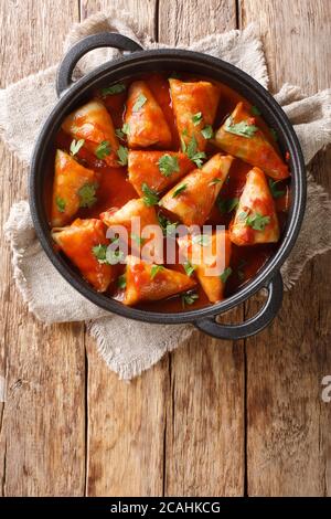 Delicious hot cabbage rolls with meat and rice in tomato sauce close-up in a bowl on the table. Vertical top view from above Stock Photo