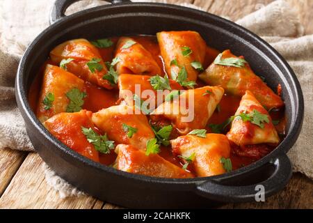Stuffed cabbage leaves with minced meat and rice in tomato sauce close-up in a bowl on the table. horizontal Stock Photo