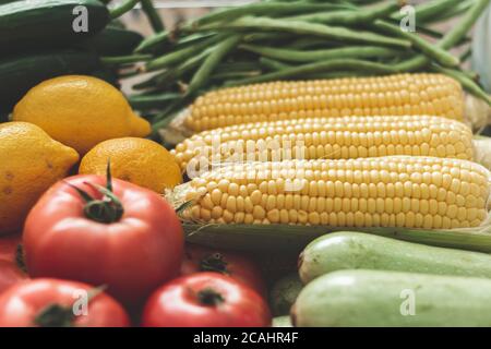 vegetables on the refrigerator shelf, autumn vegetables. full of corn, tomatoes, peppers, zucchini, cabbage, lemon, vegetables. Stock Photo