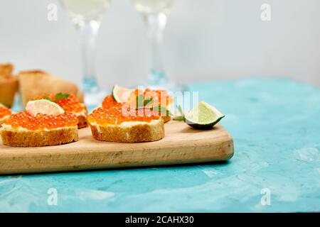 Salmon red caviar in bowl and Sandwiches with on wooden cutting board Stock Photo