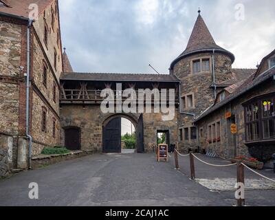 Czocha, Poland-August 25, 2019: View on main gate and outer bastion from the inside of castle bailey. Visible tourist bar and the ticket sales point. Stock Photo