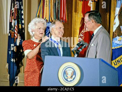In this file photo, United States President George H.W. Bush, right, and first lady Barbara Bush, left, award the Presidential Medal of Freedom to National Security Advisor Brent Scowcroft, center,  in the East Room of the White House in Washington, DC on July 3, 1991.Credit: Howard L. Sachs / CNP / MediaPunch Stock Photo