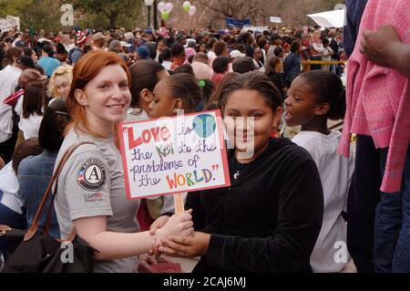 Anglo and African American girls hold sign promoting love and tolerance at Martin Luther King Jr. Day celebration, Austin, TX. ©Janis Daemmrich Stock Photo