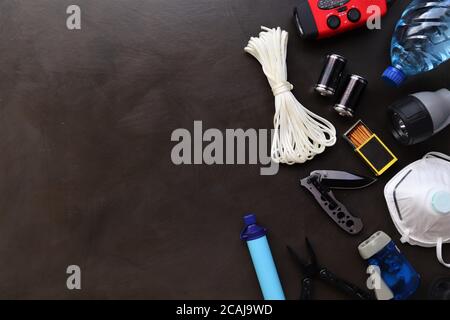 Flat lay view of essential disaster preparedness items arranged neatly for a go bag, including emergency supplies, first aid materials Stock Photo