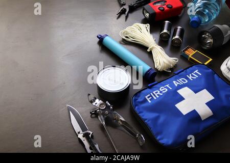 Flat lay view of essential disaster preparedness items arranged neatly for a go bag, including emergency supplies, first aid materials Stock Photo