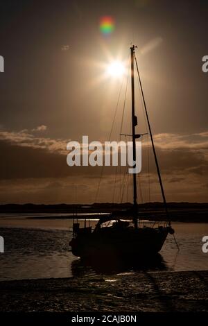 Yacht in silhouette at Ravenglass, Lake District, England Stock Photo