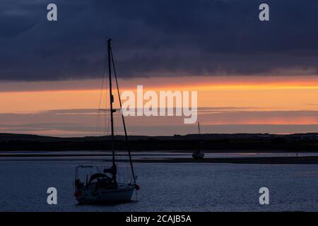 Yacht in silhouette at Ravenglass, Lake District, England Stock Photo