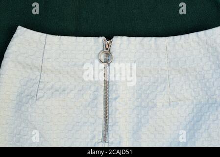 Silver zipper on pale green textured clothes. Close-up Stock Photo