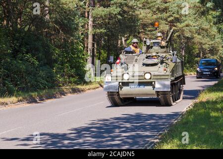 Spartan FV103 armoured vehicle with L plate learner driver, driving along road at Bovington, Dorset UK in August, Armoured Vehicle Driving Assessments Stock Photo