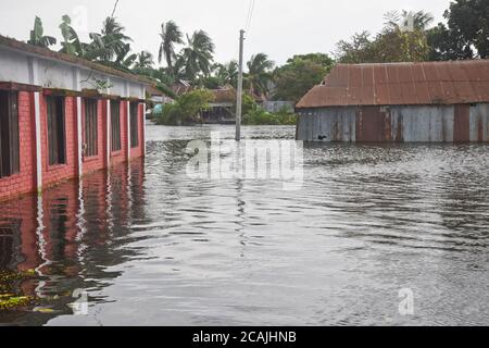 Village houses are seen surrounded by the flood water in Savar near Dhaka, Bangladesh, on August 7, 2020 Stock Photo