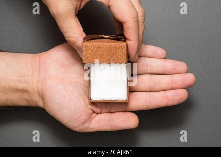 Male hands with an empty open brown jewelry box. Present. Black background Stock Photo