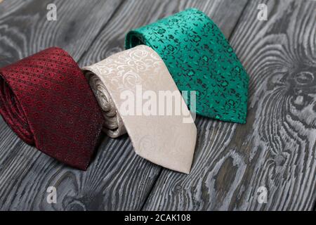 Three men's ties in different colors and sizes. For father and sons. Love and Togetherness Objects. On painted boards. Stock Photo