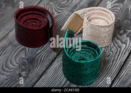 Three men's ties in different colors and sizes. For father and sons. Love and Togetherness Objects. On painted boards. Stock Photo