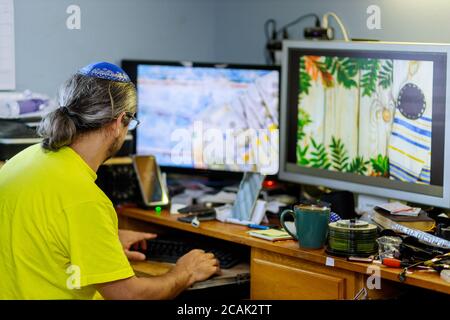 Jewish man designer working home on his typing texting on computer in a at office desk wooden table Stock Photo