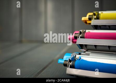 Magenta, cyan and yellow laser print ink cartridges on wood background Stock Photo
