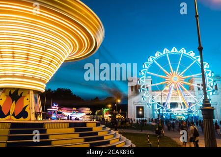 MUNICH, GERMANY - Jul 26, 2020: The illuminated carousel spins in the night. 2020 'summer in the city' folk festival in Munich, despite corona virus p Stock Photo