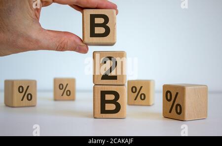 Male hand placing a cube with letter B on top of a other cubes. B2B text. Beautiful white background. Stock Photo