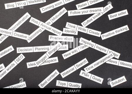 Word cloud of business themes cut out of paper on a gray background. Stock Photo
