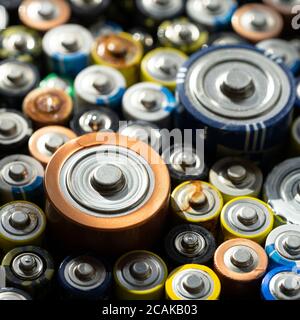 Close up of positive ends of discharged batteries of different sizes and formats, selective focus. Used alkaline battery. Hazardous garbage concept Stock Photo