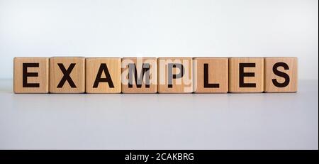 Concept word 'examples' on wooden cubes on a beautiful wooden table. White background. Business concept. Stock Photo