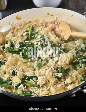 Homemade Greek spanakorizo with rice and spinach simmering in a pan Stock Photo