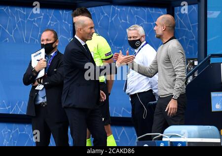 Real Madrid's Zinedine Zidane (left) and Manchester City manager Pep Guardiola prior to kick-off during the UEFA Champions League, round of 16, second leg match at the Etihad Stadium, Manchester. Friday August 7, 2020. See PA story soccer Man City. Photo credit should read: Peter Powell/NMC Pool/PA Wire. RESTRICTIONS: Editorial Use Only, No Commercial Use Stock Photo