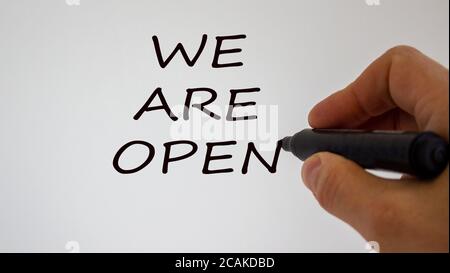 Hand writing 'we are open', isolated on beautiful white background. Concept. Stock Photo